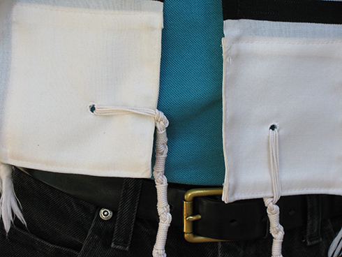 The tzitzit should hang down along the vertical border (screen left/model's right side)